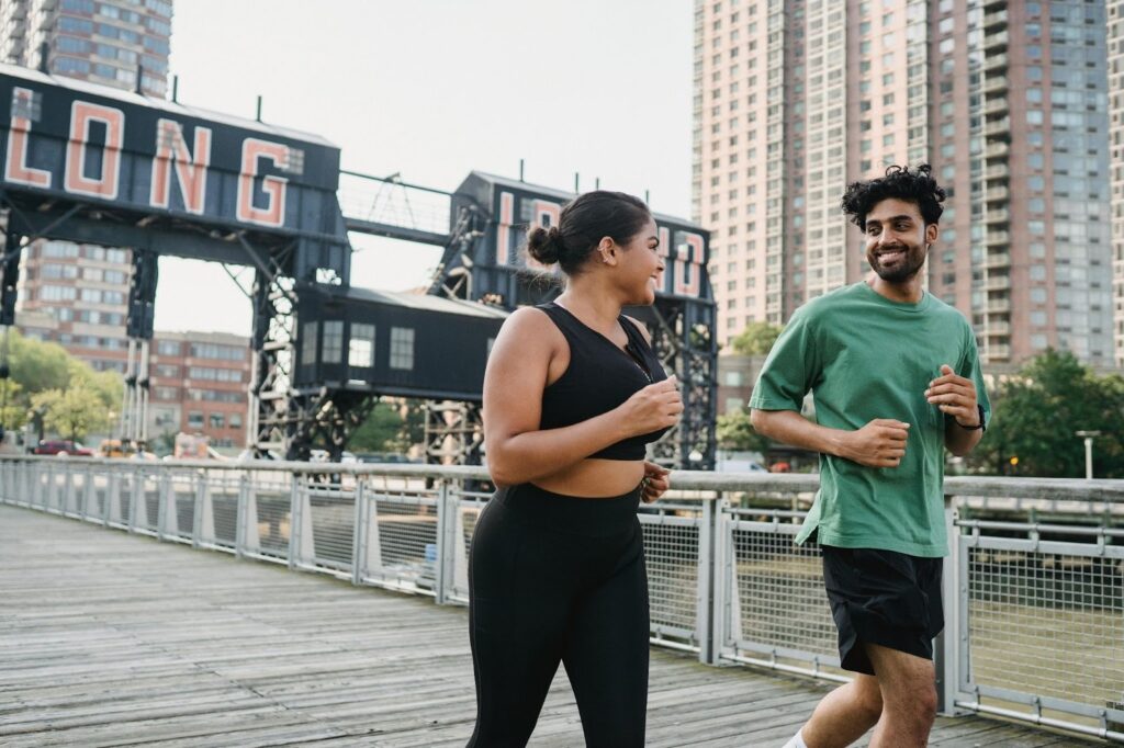 Two people running in a city 