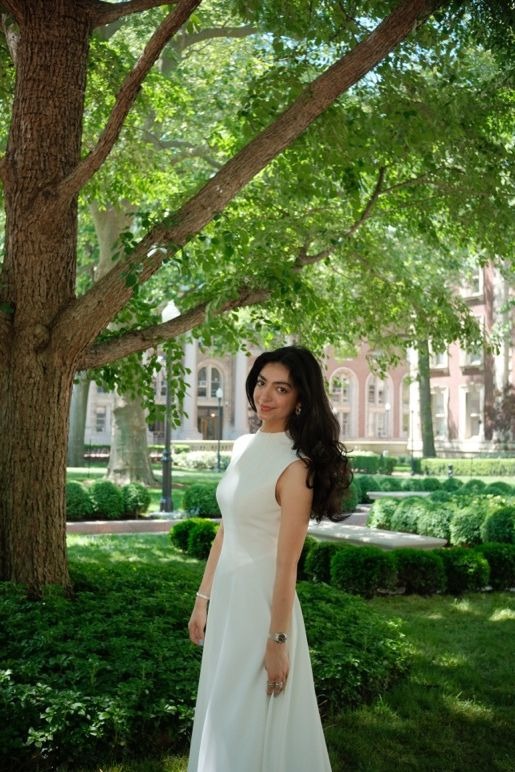 a smiling person standing in a park